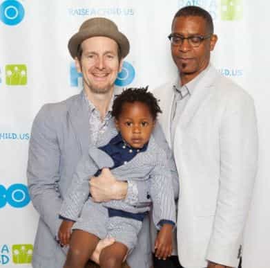 Dennis O'Hare and Hugo Redwood with their foster son, Declan Redwood O'Hare. What does O'Hare's husband do for a living?
